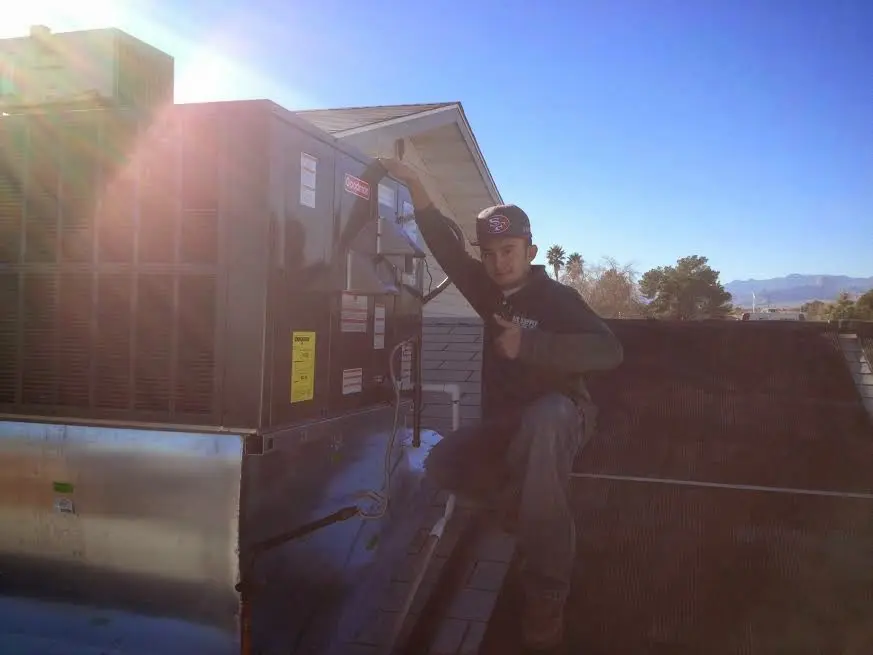 HVAC technician performing Air Duct Cleaning on a rooftop unit in Seabrook